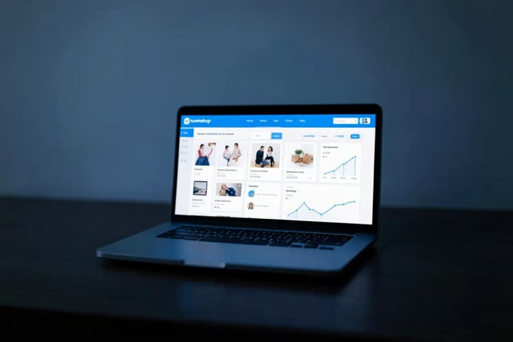 Um notebook aberto exibindo a interface da Nuvemshop com elementos de e-commerce.