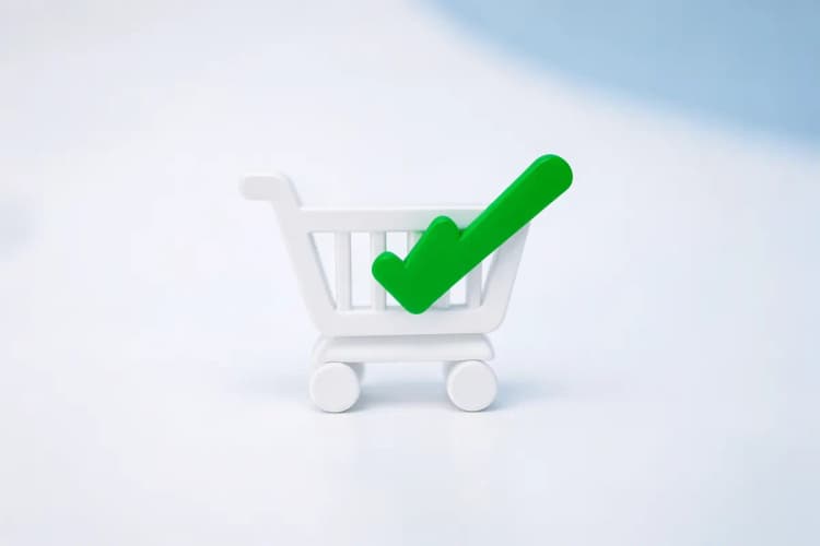 Um ícone de carrinho de compras com um sinal de checkmark, representando a otimização da experiência do usuário em um e-commerce.
