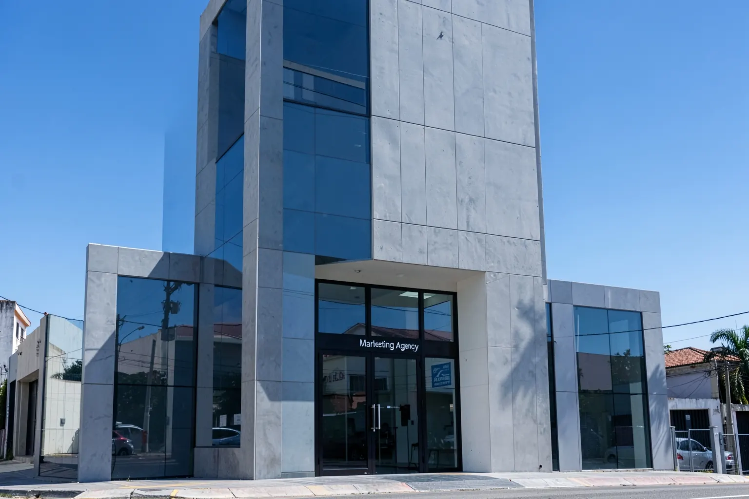 Fachada de prédio comercial moderno com o nome "Agência de Marketing" em destaque na entrada, em um dia ensolarado em Guarulhos