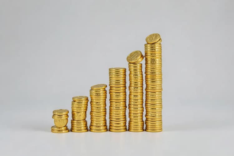 Um gráfico de barras ascendente feito de moedas de ouro, representando o crescimento do tráfego pago.